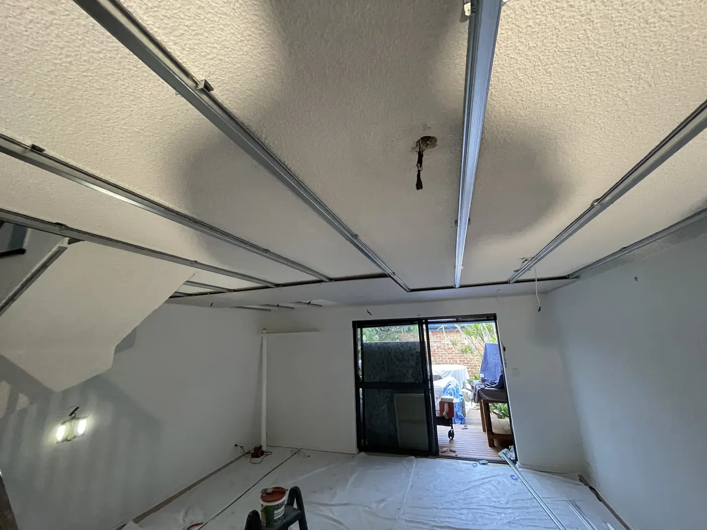 Metal ceiling tracks fixed across an old textured ceiling in a Bayswater living room